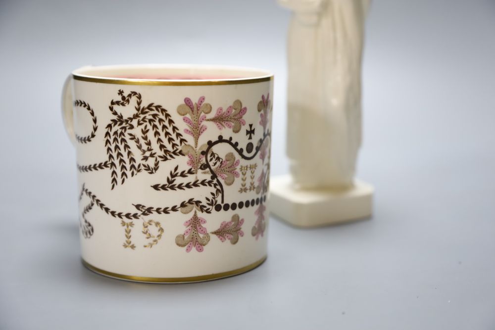 A Wedgwood commemorative Coronation mug designed by Richard Guyatt and an earthenware figure of a grape-carrier, indistinct signature b